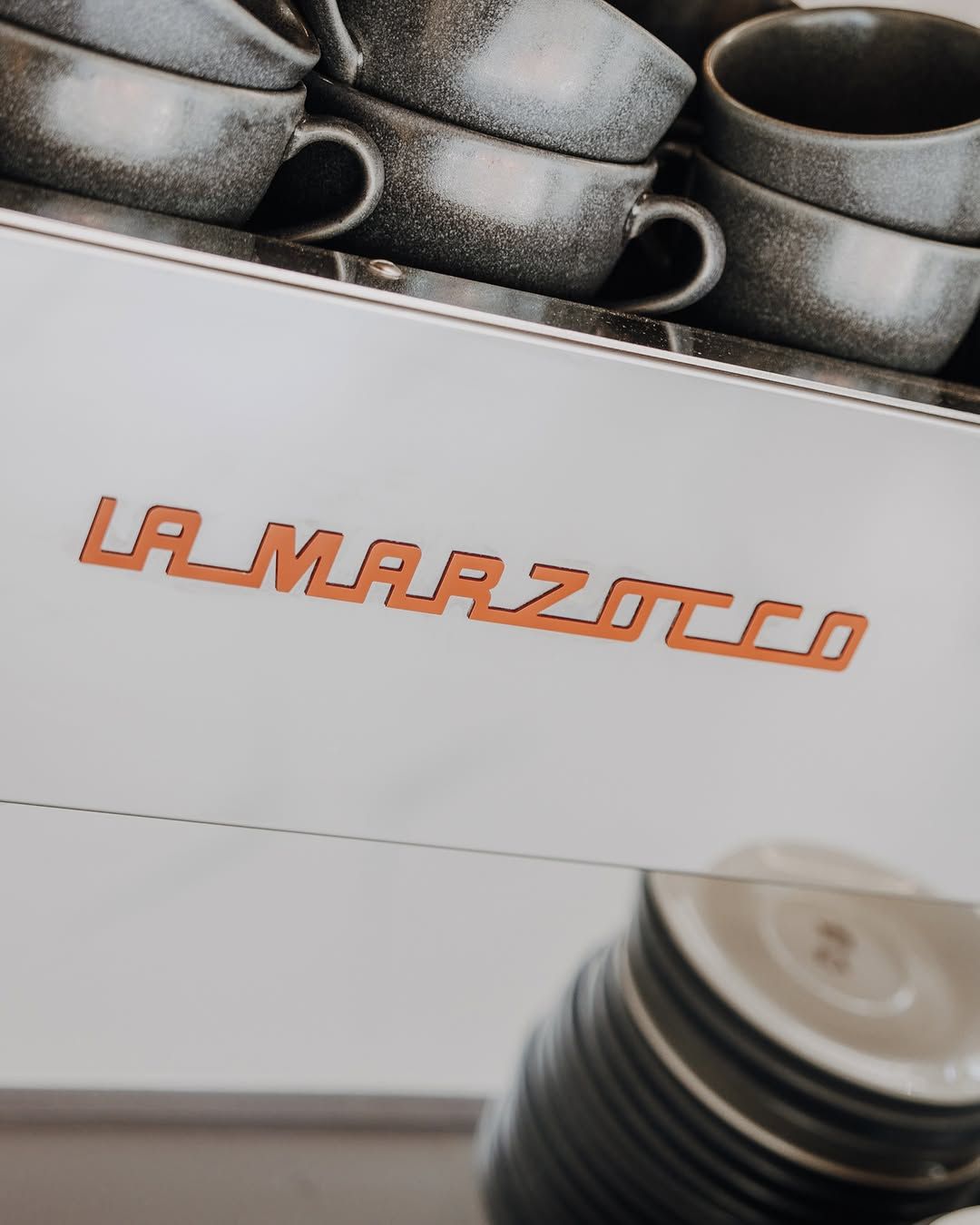 Detalle de la máquina La Marzocco y tazas de cerámica