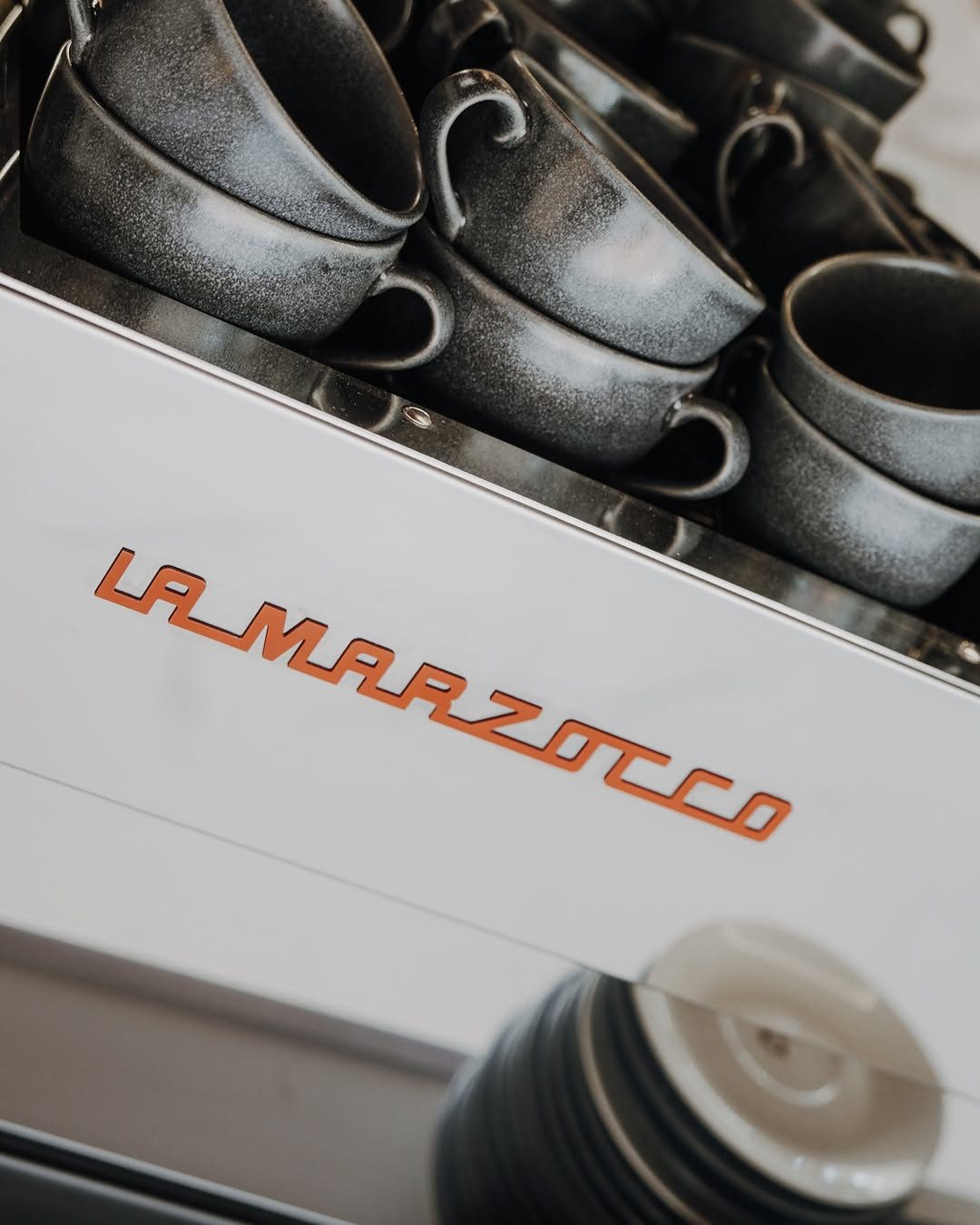 Máquina de espresso La Marzocco de Maruka con tazas apiladas
