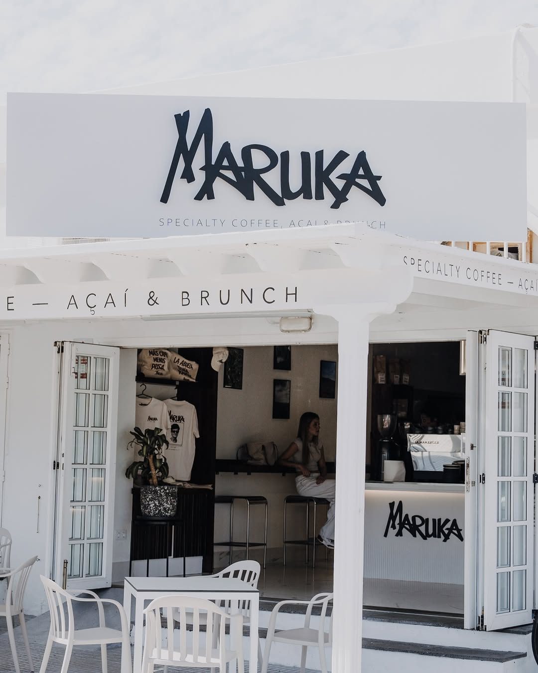 Terraza exterior de Maruka con sillas blancas